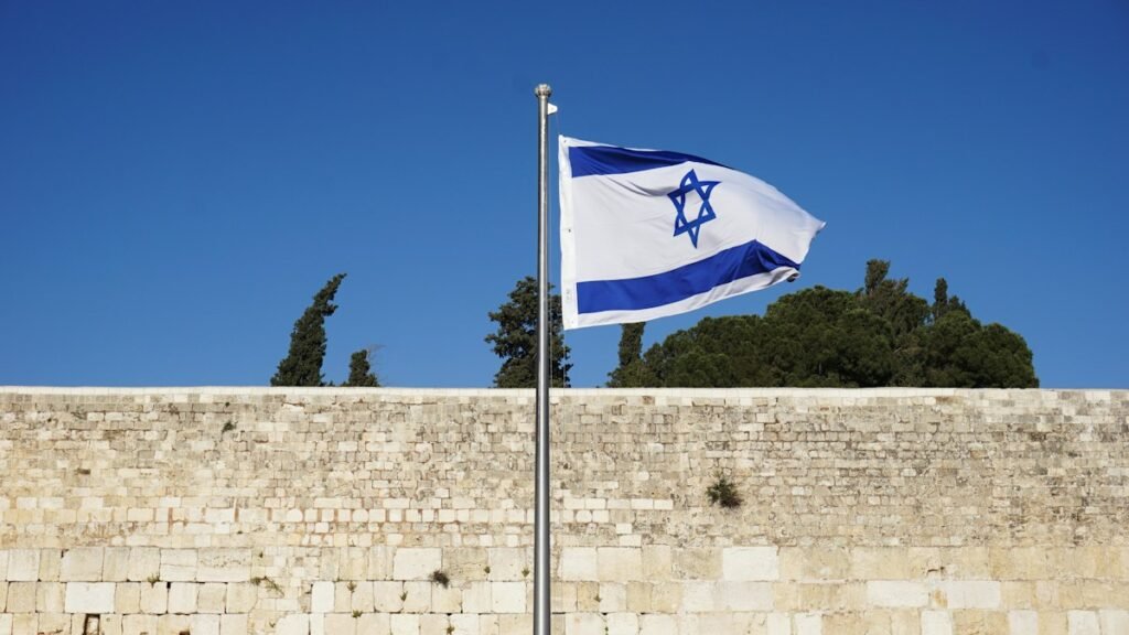 Israeli flag on a pole against the sky, a stock photo illustrating the Israel election