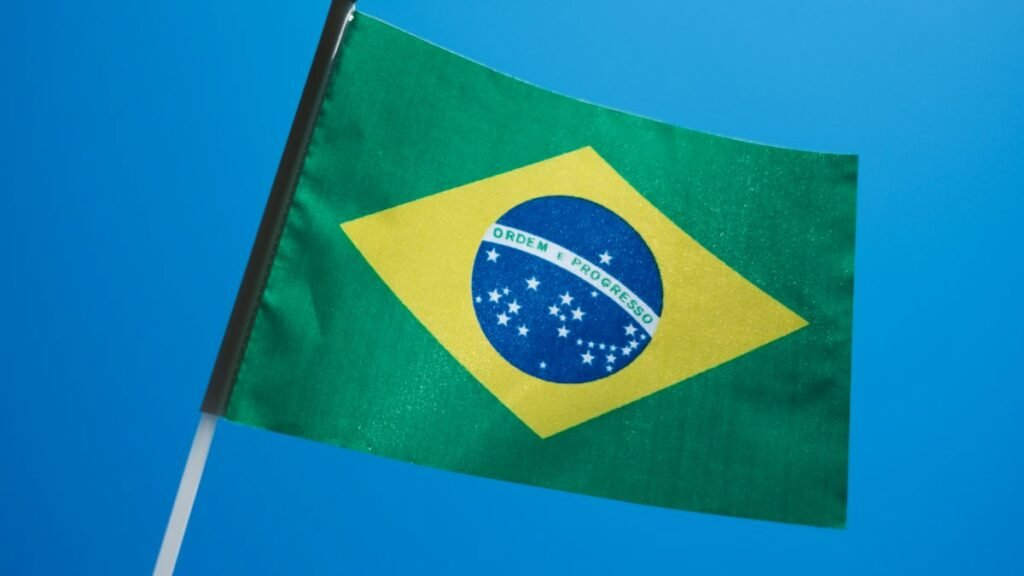 Brazilian flag flying against a blue sky, a stock photo illustrating the Lula Brazil election result