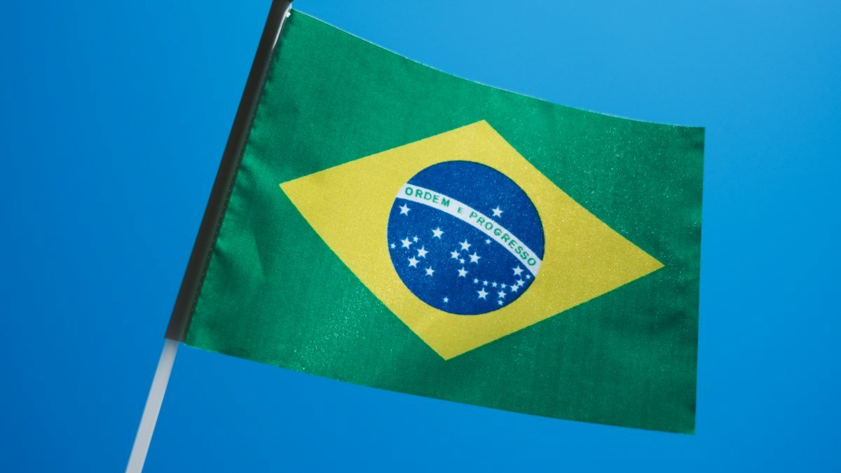 Brazilian flag flying against a blue sky, a stock photo illustrating the Lula Brazil election result