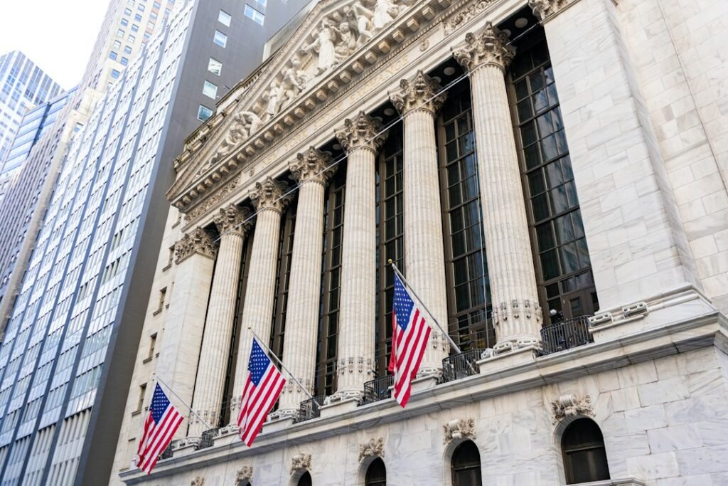 New York Stock Exchange building with American flags on Wall Street