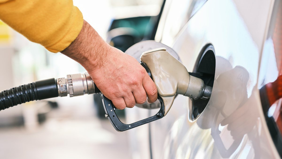 Man pumping gas at a gas station, a stock photo illustrating the oil prices surge