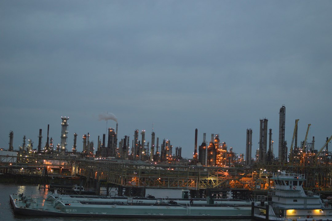 Industrial oil refinery complex at dusk, representing Russian oil and diesel sanctions
